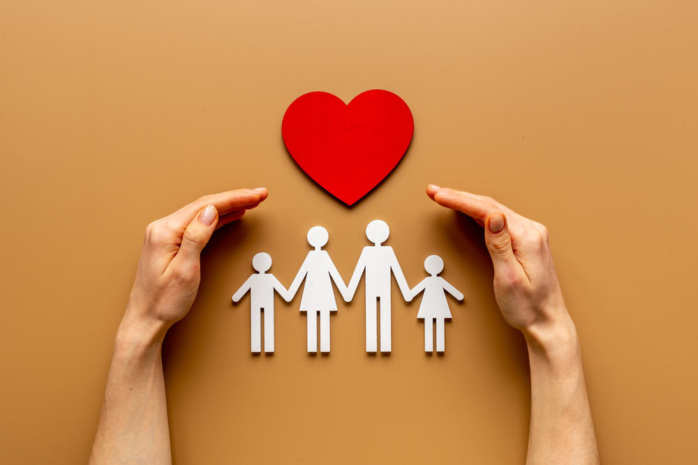 hands with family cut out and heart to signify life insurance