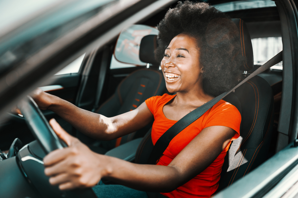 young african american woman driving car smiling